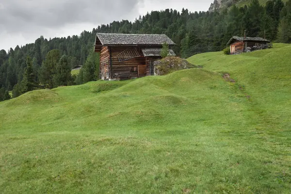 Dolomitler 'de bir dağ otlağının üzerinde harika manzaralı küçük bir ev.