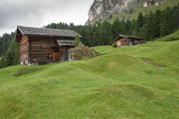 Dolomitler 'de bir dağ otlağının üzerinde harika manzaralı küçük bir ev.