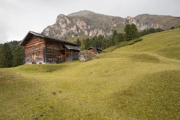 Dolomitler 'de bir dağ otlağının üzerinde harika manzaralı küçük bir ev.
