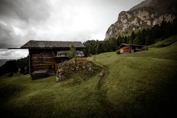 Dolomitler 'de bir dağ otlağının üzerinde harika manzaralı küçük bir ev.