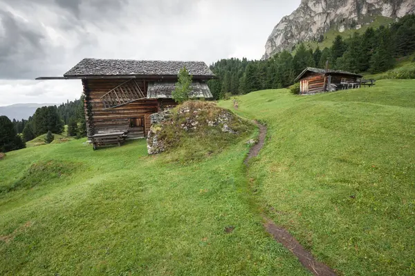 Dolomitler 'de bir dağ otlağının üzerinde harika manzaralı küçük bir ev.