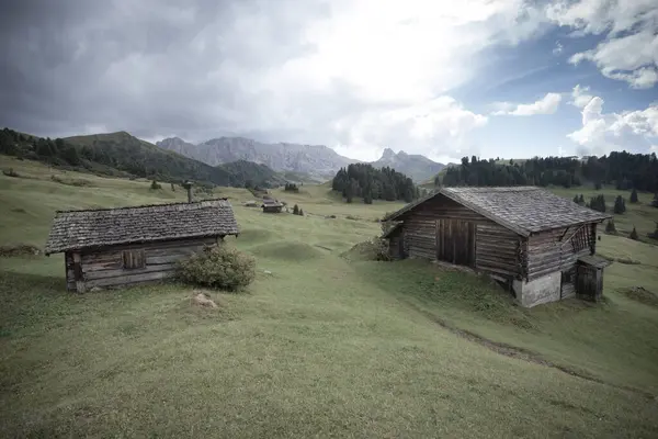 Dolomitler 'de bir dağ otlağının üzerinde harika manzaralı küçük bir ev.