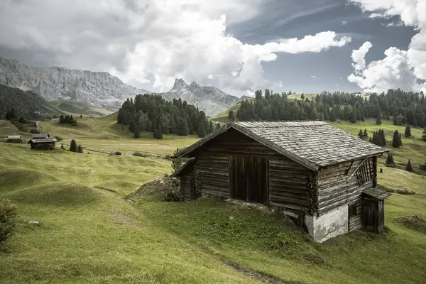 Dolomitler 'de bir dağ otlağının üzerinde harika manzaralı küçük bir ev.