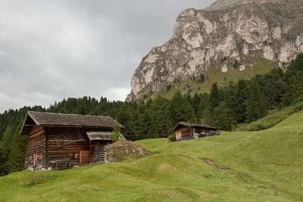 Dolomitler 'de bir dağ otlağının üzerinde harika manzaralı küçük bir ev.