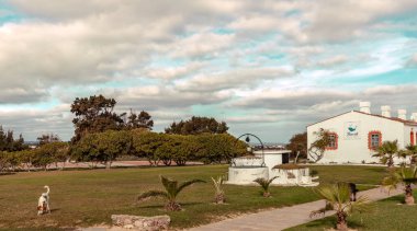 Portekiz 'in güneyindeki Santa Luzia' da eski balıkçı kulübelerinin eviyle Barril sahilinde manzara.