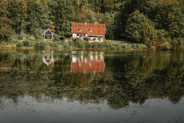 Kuzey Ren-Vestfalya 'daki Teutoburg Ormanı' ndaki göl kenarındaki ev.