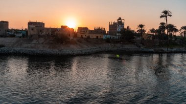 Gün batımında Nil 'in kıyısındaki yerleşim alanının görüntüsü