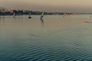 Dostlar gün batımında Nil 'de yelkenli sürüyor.