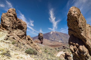 İspanya, Kanarya Adaları, Tenerife 'deki ünlü El Teide volkanı. Volkanik manzara, mavi gökyüzü ve beyaz bulutlar..