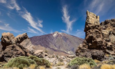 İspanya, Kanarya Adaları, Tenerife 'deki ünlü El Teide volkanı. Volkanik manzara, mavi gökyüzü ve beyaz bulutlar..