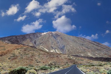 İspanya, Kanarya Adaları, Tenerife 'deki ünlü El Teide volkanı. Volkanik manzara, mavi gökyüzü ve beyaz bulutlar..