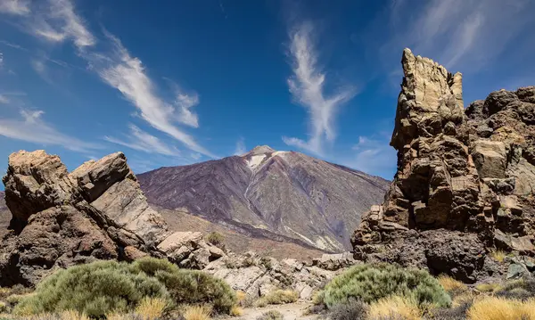 İspanya, Kanarya Adaları, Tenerife 'deki ünlü El Teide volkanı. Volkanik manzara, mavi gökyüzü ve beyaz bulutlar..
