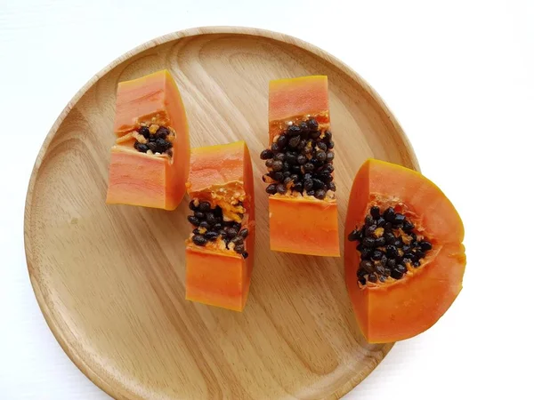 stock image Ripe papaya fruit on wood dish with white background.