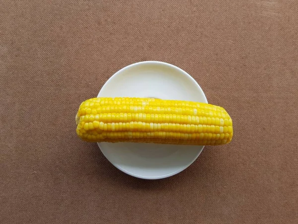 白い背景の白いプレートに黄色いトウモロコシ — ストック写真