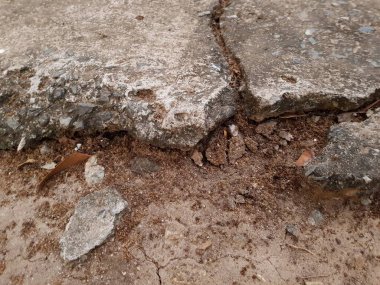 Çatlak yol yüzeyinde çatlaklar ve çizikler var.