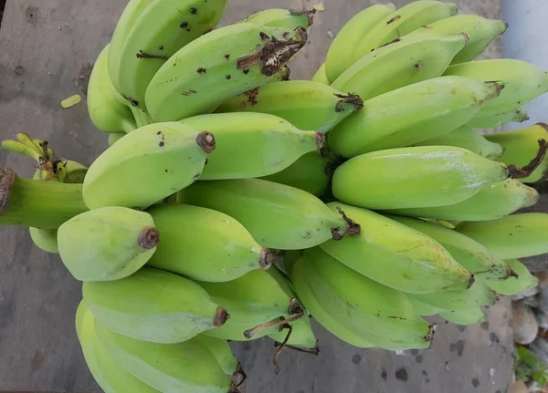 木质背景下的绿色香蕉果 — 图库照片