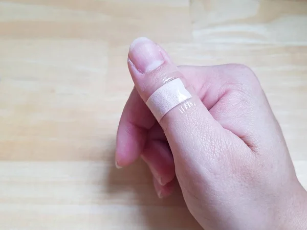 Kobieta Przyklejająca Tynk Rany Kciuka — Zdjęcie stockowe