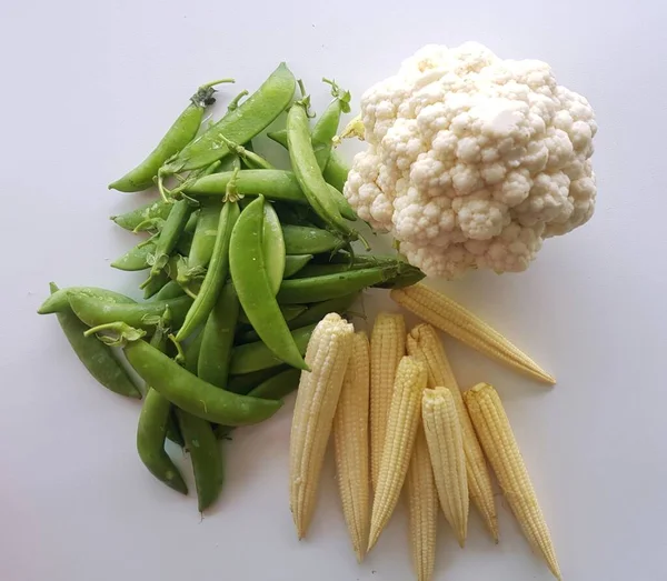 Green peas, baby corn and cauliflower vegetable on white background.
