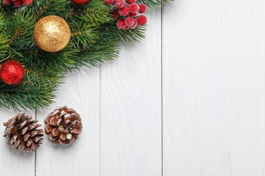 Noel kompozisyonu, oyuncaklı Noel ağacı dalı, ahşap arka planda koniler.