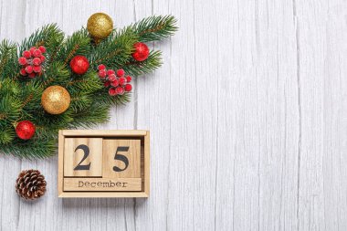 Oyuncak ve hediyelerle Noel ağacı dalı ve tahta takvim 25 Aralık ahşap arka planda yakın plan