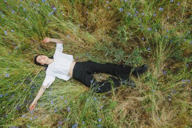 Yaz tarlalarının arasında kır çiçekleriyle güzel bir kız.