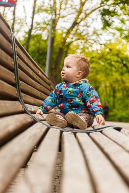 portrait of a little boy in the park on a bench catching soap bubbles close-up