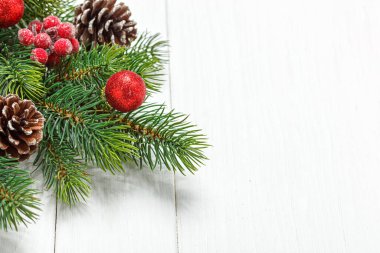 Noel kompozisyonu, oyuncaklı Noel ağacı dalı, ahşap arka planda koniler.