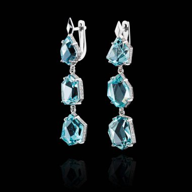 Aquamarine ve elmaslarla kaplanmış güzel altın küpeler. Yakın plan.