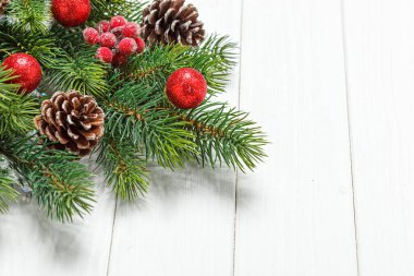 Noel kompozisyonu, oyuncaklı Noel ağacı dalı, ahşap arka planda koniler.