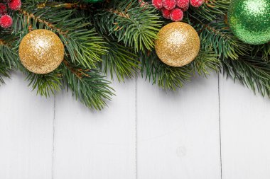 Beyaz ahşap arka planda koni ve oyuncakları olan bir Noel ağacının güzel dalları.