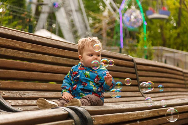 Portrait Little Boy Park Bench Catching Soap Bubbles Close — Stockfoto