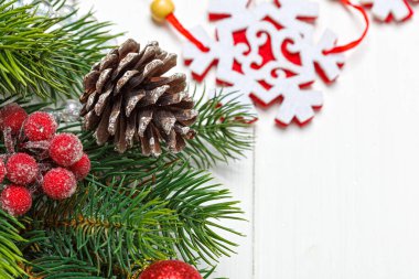 Noel kompozisyonu, oyuncaklı Noel ağacı dalı, ahşap arka planda koniler.