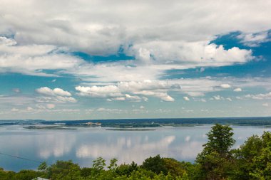 Su, nehir, deniz manzarası. Mavi gökyüzüne bakan bulutlar.