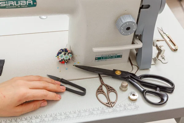 Sewing machine with sewing tools, scissors, threads close-up