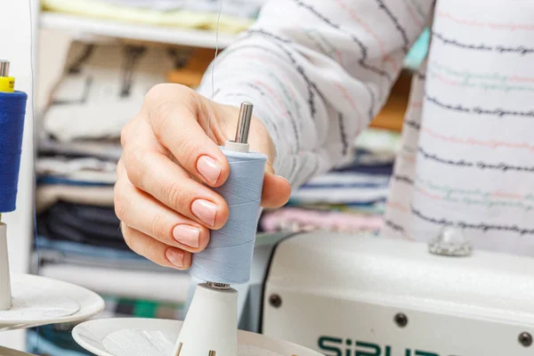 stock image Adjusting the sewing machine, threads in female hands close-up