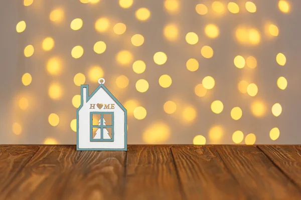 christmas wooden house on the background of blurry lights close-up