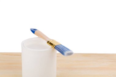 white paint with a brush on a wooden background with texture close-up