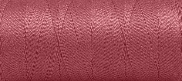 白い背景の上の赤い色のスプール内の糸のテクスチャクローズアップ — ストック写真
