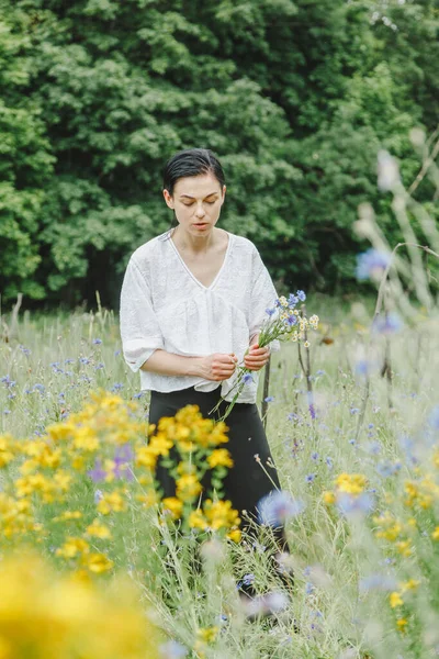 stock image Beautiful girl among the summer field with wildflowers close-up