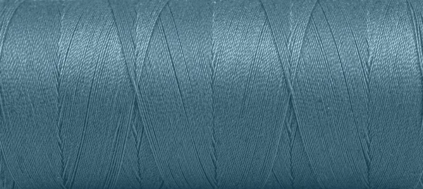 白い背景の上の青い色のスプール内の糸のテクスチャクローズアップ — ストック写真