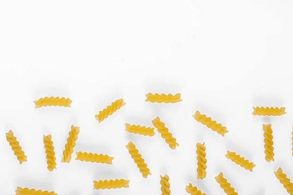 Pasta products in the form of a spiral, texture, on a white background close-up