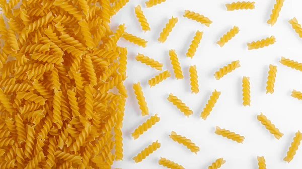 Pasta products in the form of a spiral, texture, on a white background close-up