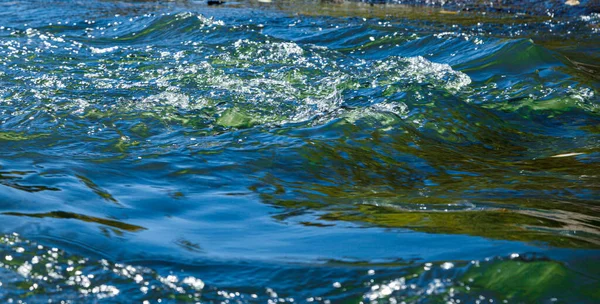 石の近くからの水とスプレーの流れ — ストック写真