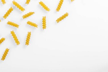 Pasta products in the form of a spiral, texture, on a white background close-up