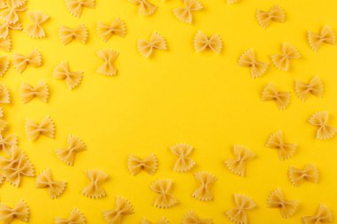 Sarı arka planda farklı şekillerde kuru İtalyan makarnası.