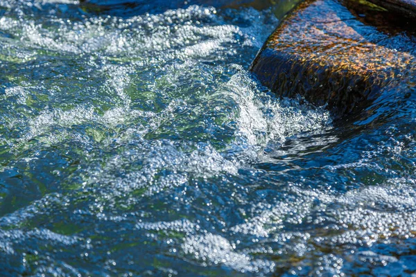 石の近くからの水とスプレーの流れ — ストック写真