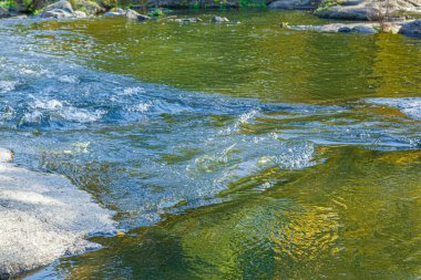 Su akışı ve bir taştan fışkırma. Yakından.