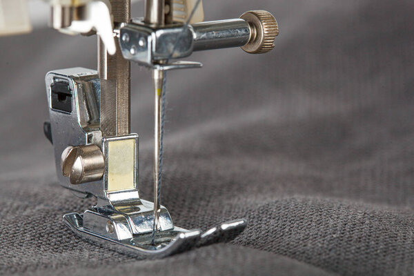 Швейная машина, сшивальная ткань, игла в круговом плане крупным планом