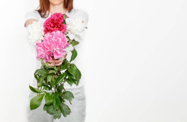 Beyaz arka planda bir kızın ellerinde güzel şakayıklar.