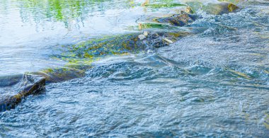 Su akışı ve bir taştan fışkırma. Yakından.